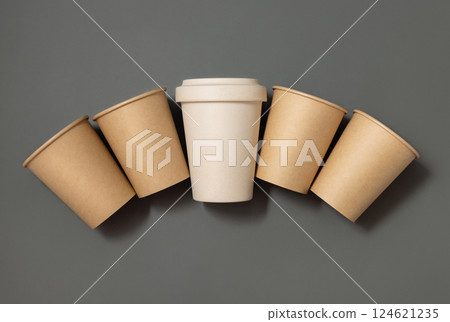 New beige kraft paper cups and reusable bamboo coffee cup on a gray top view, mockup 124621235