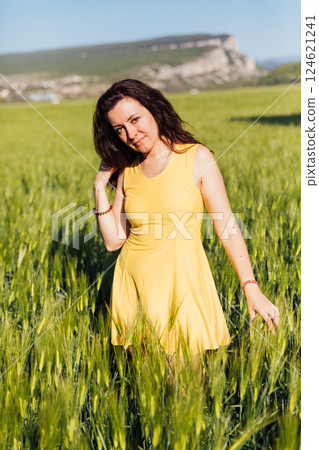 Woman in Yellow Dress Walking Through Wheat Field Harvest 124621241