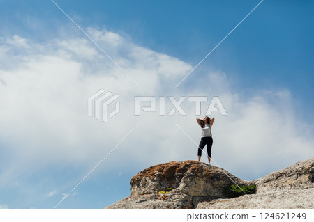Female traveler looking at the view from the top of the mountain on a hike 124621249