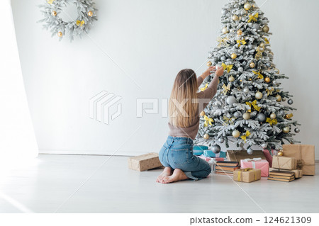 Beautiful woman Christmas tree with gifts for the new year with balloons and toys Beautiful woman Christmas tree with gifts for the new year with balloons and toys 124621309