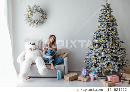 Woman with Bear Toy and Christmas Tree with New Year Gifts 124621312