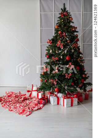 Living room interior with a Christmas tree decorated with gifts for the new year Living room interior with a Christmas tree decorated with gifts for the new year 124621369