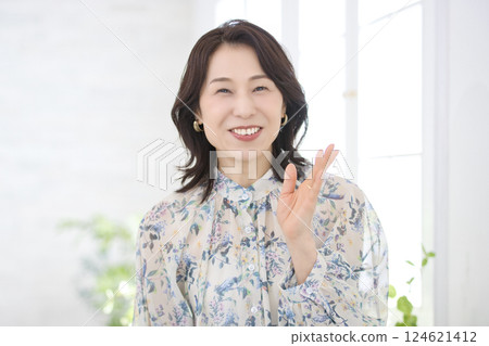 A smiling middle-aged woman wearing a floral blouse 124621412