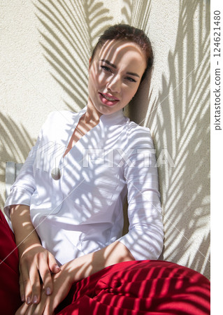 Portrait of a beautiful fashionable woman in the shade of a tropical palm tree 124621480
