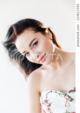 Beautiful brunette woman in summer dress with flowers on white background Beautiful brunette woman in summer dress with flowers on white background 124621485