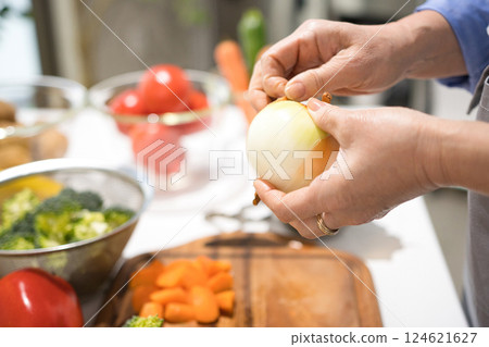 Hands of a middle-aged woman cutting vegetables 124621627