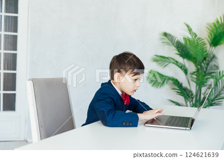 Schoolboy In Jacket At Desk Playing In Laptop Online 124621639