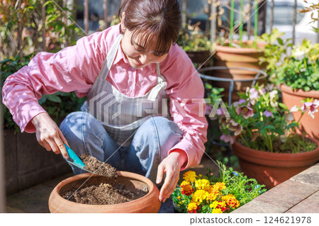 Woman planting flowers Gardening 124621978