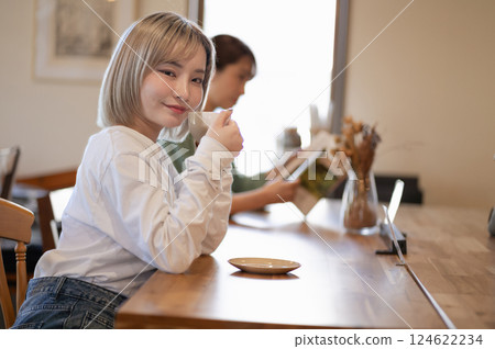 A young woman drinking coffee at a cafe 124622234