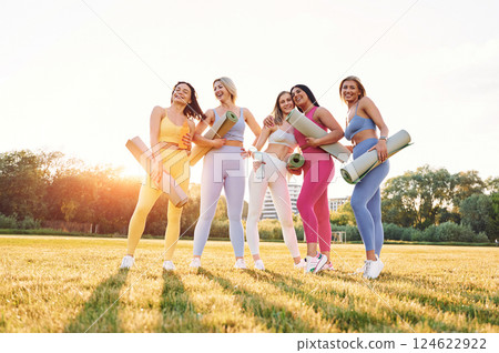 Standing and posing. Group of women have fitness outdoors on the field together Standing and posing. Group of women have fitness outdoors on the field together 124622922