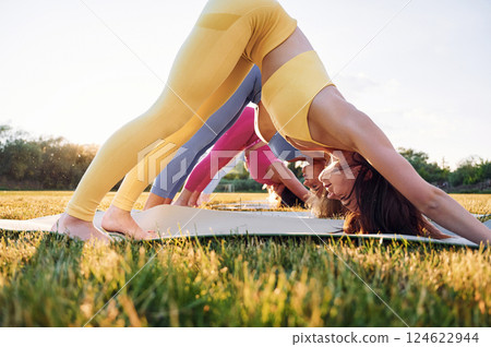 Side view. Group of women have fitness outdoors on the field together 124622944