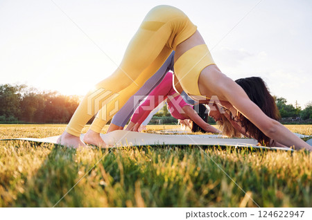 Side view. Group of women have fitness outdoors on the field together 124622947