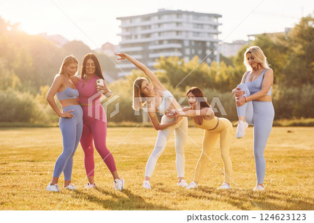 Conception of teamwork. Group of women have fitness outdoors on the field together Conception of teamwork. Group of women have fitness outdoors on the field together 124623123