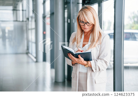 Woman in white formal clothes is in the car dealership Woman in white formal clothes is in the car dealership 124623375