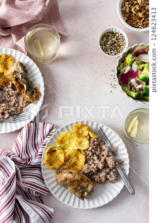 A nutritious, balanced breakfast featuring green buckwheat, fried hake, zucchini, and a fresh broccoli salad with pink radish, seeds, and nuts, offering a wholesome start to the day 124623413