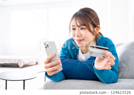 A woman shopping online on a smartphone A woman shopping online on a smartphone 124623526