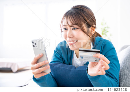 A woman shopping online on a smartphone 124623528