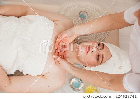 Masseur Giving Facial Massage To Woman In Spa Masseur Giving Facial Massage To Woman In Spa 124623741