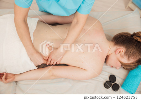 chiropractor giving medical facial massage to woman in spa 124623753