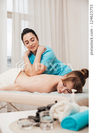 chiropractor giving medical facial massage to woman in spa 124623755