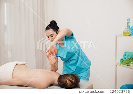 A woman is given a medical massage by a chiropractor A woman is given a medical massage by a chiropractor 124623756
