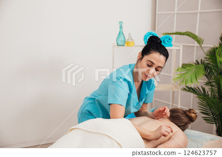 A woman is given a medical massage by a chiropractor A woman is given a medical massage by a chiropractor 124623757