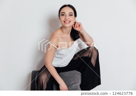 Beautiful slender woman sitting on chair at home Beautiful slender woman sitting on chair at home 124623776