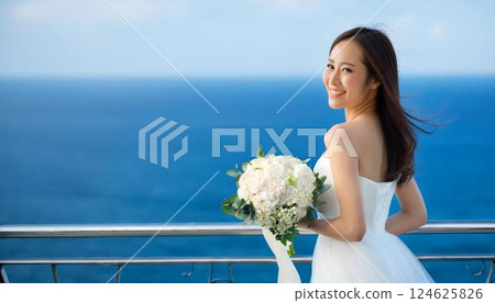 一位身穿白色婚紗的女子手捧花束，在藍色的大海映襯下，露出幸福的微笑。 124625826