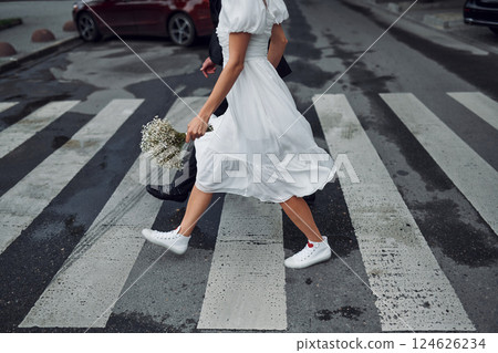 On the crosswalk. Beautiful bride with his fiance is celebrating wedding outdoors 124626234