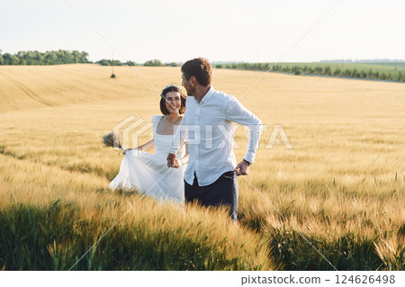 Couple just married. Together on the majestic agricultural field at sunny day 124626498