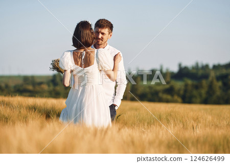 Couple just married. Together on the majestic agricultural field at sunny day Couple just married. Together on the majestic agricultural field at sunny day 124626499