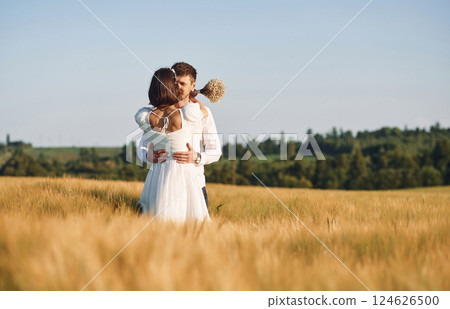 Couple just married. Together on the majestic agricultural field at sunny day Couple just married. Together on the majestic agricultural field at sunny day 124626500