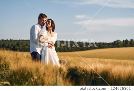 Couple just married. Together on the majestic agricultural field at sunny day Couple just married. Together on the majestic agricultural field at sunny day 124626501