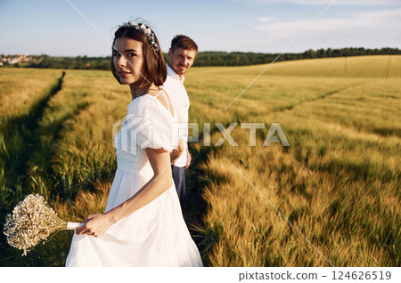 Conception of love. Couple just married. Together on the majestic agricultural field at sunny day 124626519