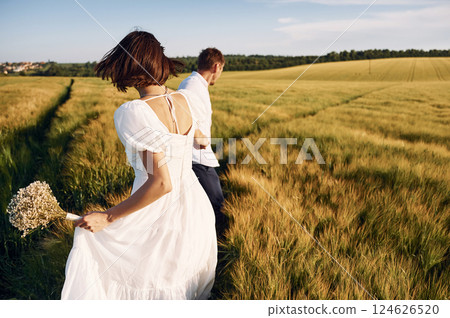 Conception of love. Couple just married. Together on the majestic agricultural field at sunny day Conception of love. Couple just married. Together on the majestic agricultural field at sunny day 124626520