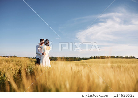 Conception of love. Couple just married. Together on the majestic agricultural field at sunny day Conception of love. Couple just married. Together on the majestic agricultural field at sunny day 124626522