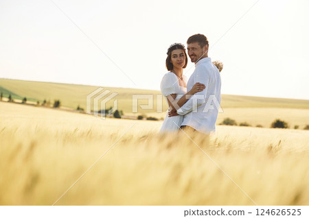 Standing and enjoying the nature. Couple just married. Together on the majestic agricultural field at sunny day 124626525