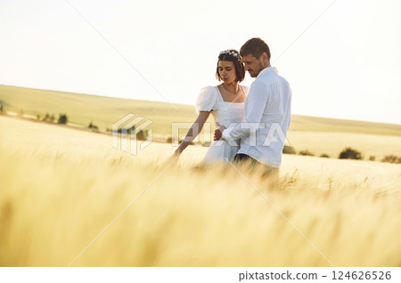 Standing and enjoying the nature. Couple just married. Together on the majestic agricultural field at sunny day 124626526