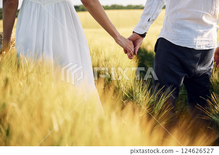 Standing and enjoying the nature. Couple just married. Together on the majestic agricultural field at sunny day 124626527