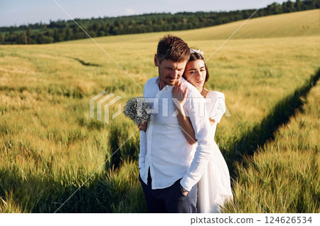 Beautiful sunlight. Couple just married. Together on the majestic agricultural field Beautiful sunlight. Couple just married. Together on the majestic agricultural field 124626534