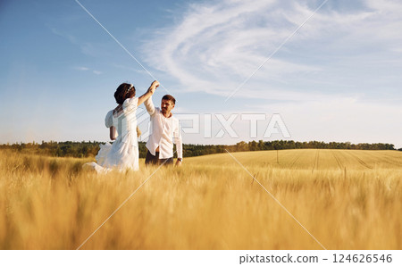 In dress and formal clothes. Couple just married. Together on the majestic agricultural field at sunny day 124626546