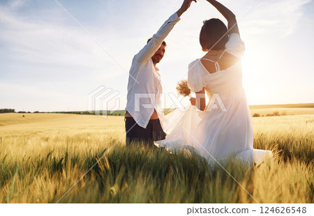 Against beautiful sunlight. Couple just married. Together on the majestic agricultural field 124626548