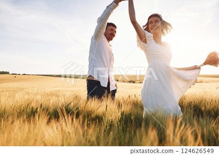 Against beautiful sunlight. Couple just married. Together on the majestic agricultural field 124626549