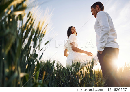 Against beautiful sunlight. Couple just married. Together on the majestic agricultural field 124626557