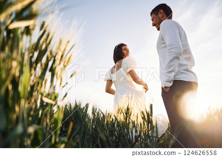 Happy people. Couple just married. Together on the majestic agricultural field at sunny day Happy people. Couple just married. Together on the majestic agricultural field at sunny day 124626558
