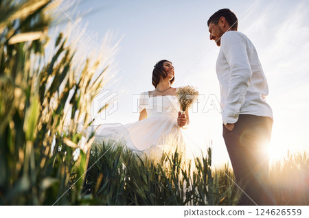 Happy people. Couple just married. Together on the majestic agricultural field at sunny day Happy people. Couple just married. Together on the majestic agricultural field at sunny day 124626559