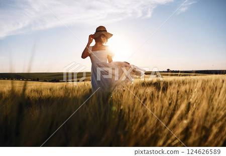 Nice landscape. Beautiful young bride in white dress is on the agricultural field at sunny day 124626589