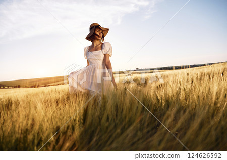 Nice landscape. Beautiful young bride in white dress is on the agricultural field at sunny day 124626592