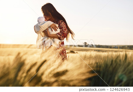 Conception of parenting. Gorgeous woman is on the agricultural field with her newborn baby 124626943