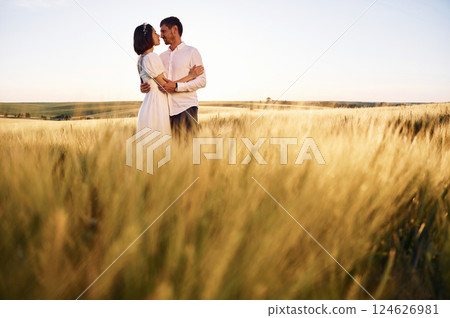 Standing and embracing. Couple just married. Together on the majestic agricultural field at sunny day Standing and embracing. Couple just married. Together on the majestic agricultural field at sunny day 124626981